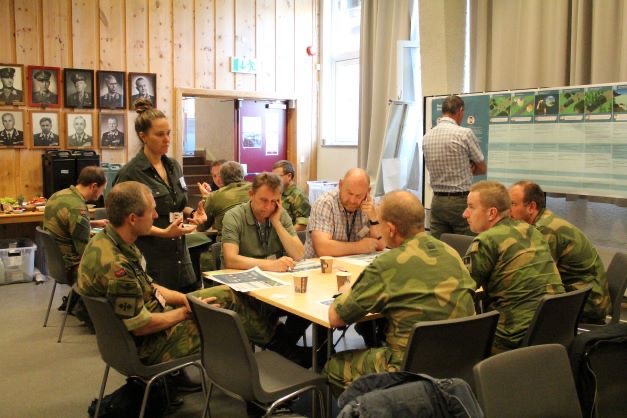 Teams in uniform working around tables during the planning conference